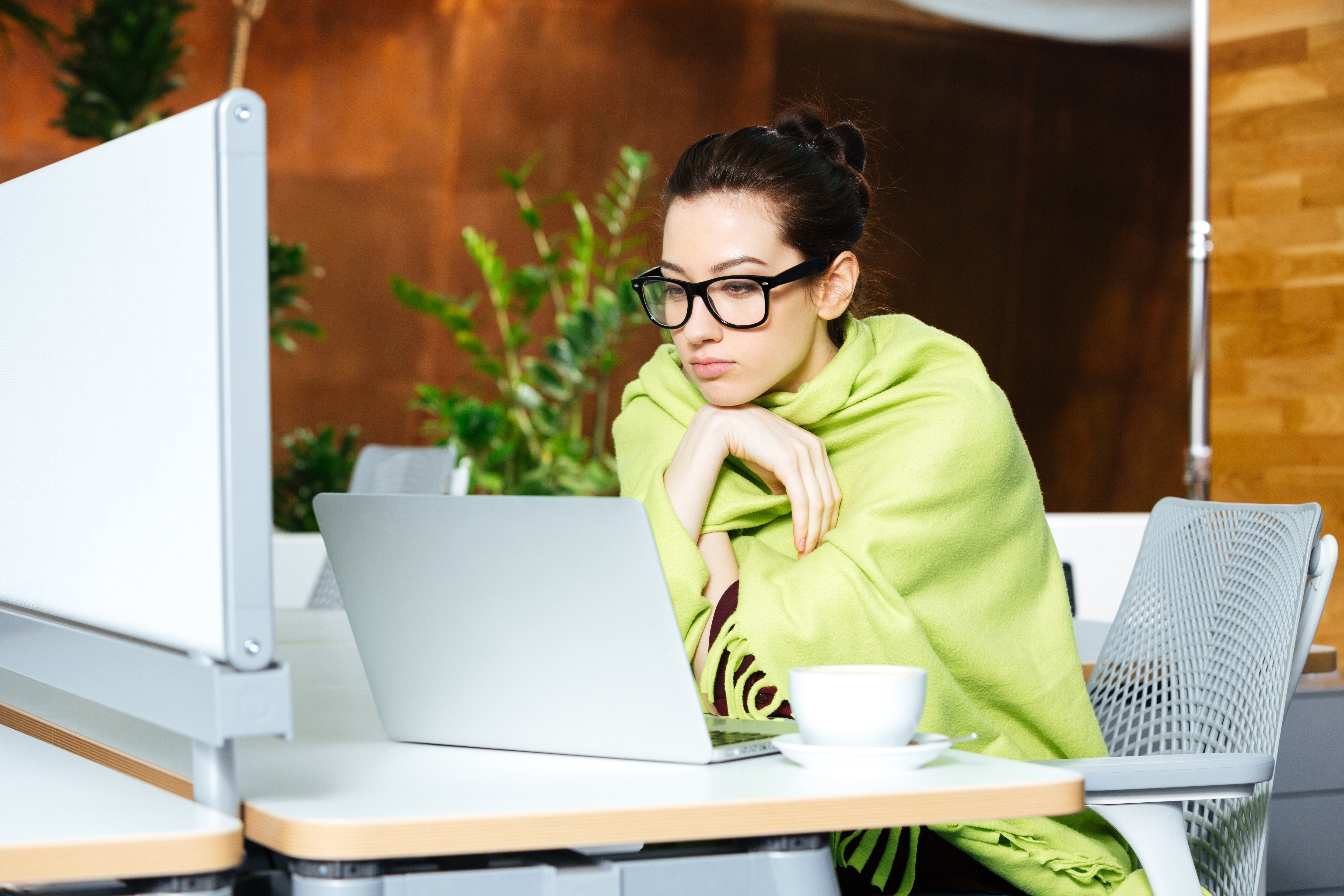 Woman in comfortable blanket in the office