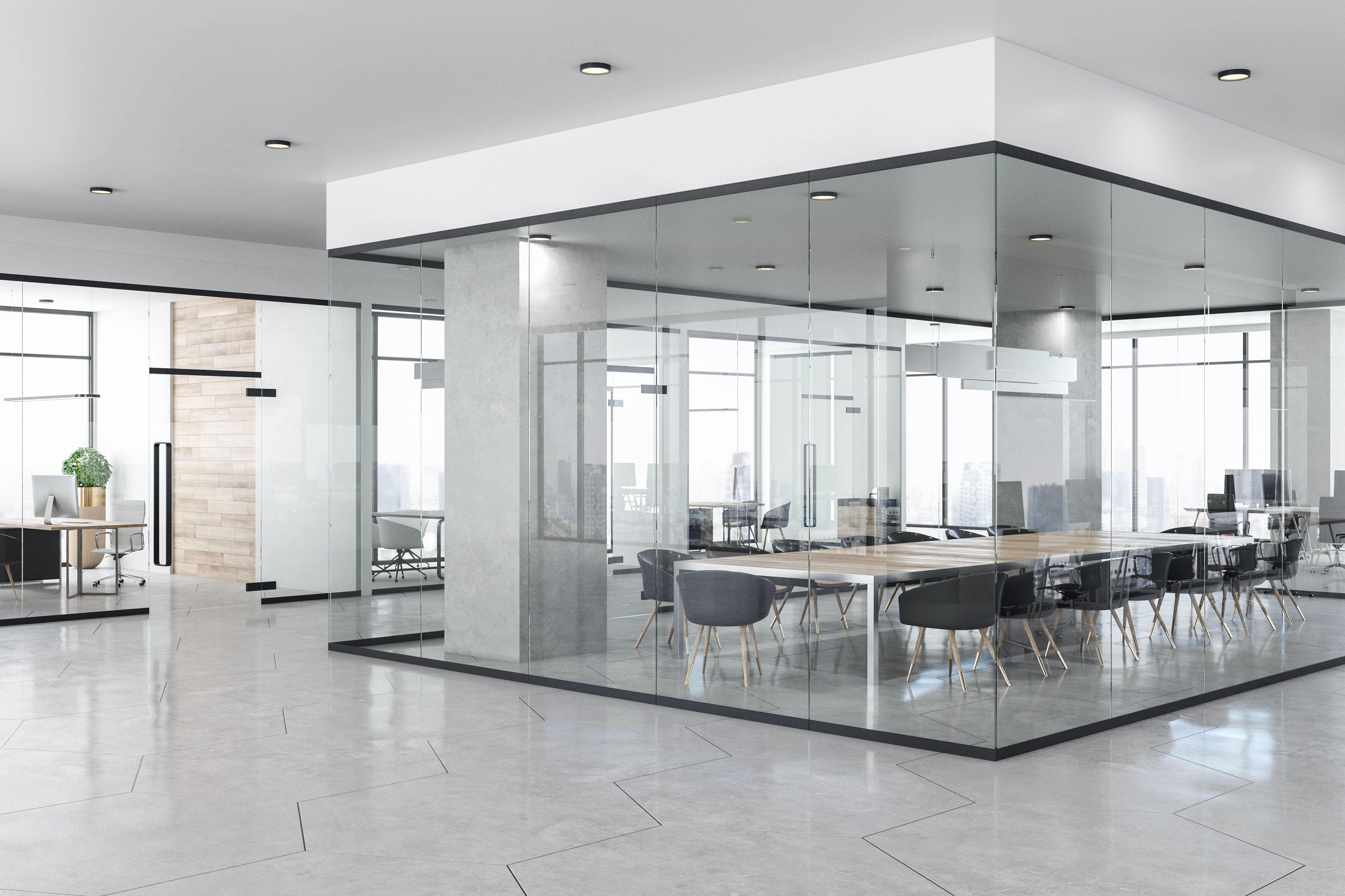 A contemporary office with a meeting room in the middle constructed with interior glass walls